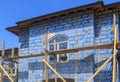 facade of cottage under construction with building grid applied to walls and guides for plaster application