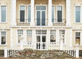 Facade of a crumbling abandoned building with white columns