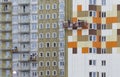 The facade decoration of a residential high-rise building. Workers complete the facade decoration while