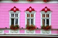 Facade decoration. White windows with flowers on pink wall Royalty Free Stock Photo