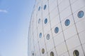 Facade detail: modern spherical building with circular windows or portholes. Quirk building architecture conveys business concept