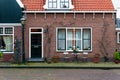 Facade of Dutch house with New Year decorations. Volendam village in Christmas. Garden furniture near a brick house in Netherlands