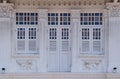 Singapore Straits Chinese Peranakan shophouse exterior with white wooden louvered shutters, ornate columns & Qilin plaster motifs