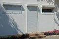 Facade of a gray house with windows and a door closed by shutters and a roller shutter Royalty Free Stock Photo