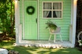 Facade green wooden house decorated for spring holidays. Exterior Wooden porch home with garden furniture. Interior cozy veranda h