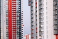 The facade of a high-rise building with red white and gray stripes. Multi-storey building against the blue sky. Background to Royalty Free Stock Photo