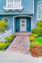 Facade Of Home With Blue Wall White Door And Beautiful Landscaped Garden