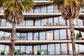 facade of a hotel with palm trees in front Royalty Free Stock Photo