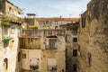 Facade in an inner courtyard in old town Centro storico of italian metropole Naples. Balconys and windows of typical residential