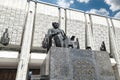 Facade Kazakh National Drama Theatre. M. Auezov with a sculpture of Auezov in front of him in the city of Almaty