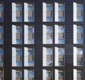 Facade of a large black and white modern commercial building with repeating windows and geometric panels