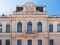 The facade of a light house with large windows with angels holding a coat of arms under a dark roof in a street in St. Petersburg Royalty Free Stock Photo