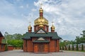 Facade log church with three gilded domes