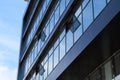 Facade of a modern building on a bright Sunny day, blue sky and clouds reflecting in a glass, beautiful exterior of the new Royalty Free Stock Photo