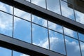 Facade of a modern building on a bright Sunny day, blue sky and clouds reflecting in a glass, beautiful exterior of the new Royalty Free Stock Photo