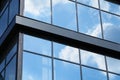 Facade of a modern building on a bright Sunny day, blue sky and clouds reflecting in a glass, beautiful exterior of the new Royalty Free Stock Photo