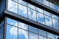 Facade of a modern building on a bright Sunny day, blue sky and clouds reflecting in a glass, beautiful exterior of the new Royalty Free Stock Photo