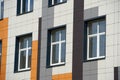 Facade of a modern building on a bright Sunny day, siding and Windows, beautiful exterior of the new building