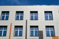 Facade of a modern building on a bright Sunny day, siding and Windows, beautiful exterior of the new building