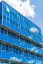 Facade of a modern building. Glass Windows reflected the sky and clouds. Blue gamma Royalty Free Stock Photo