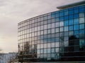 Facade of modern glass building and round shape at sunset, Clouds reflection in a windows Royalty Free Stock Photo