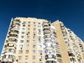 The facade of a modern residential multi-storey building against a clear blue sky. The concept of residential real estate