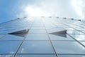 Facade of modern skyscraper with reflection of cloudy sky and sunbeams, low angle shot,copy space Royalty Free Stock Photo