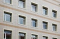 The facade of a multi-storey clinical building. The walls with many windows are finished with plastic