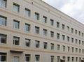 The facade of a multi-storey clinical building. The walls with many windows are finished with plastic