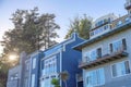 Facade of multi-storey houses and sunset peeking through trees in San Francisco, California Royalty Free Stock Photo