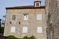 Facade of a multi-storey old stone house. The windows are covered with wooden shutters. Old Town of Budva. Montenegro Royalty Free Stock Photo