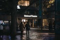 Facade of the National Theatre, London, UK, at night, selective focus, people walk in front