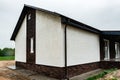 Facade of new house with decorative plaster and torn bricks. Royalty Free Stock Photo