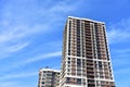 Facade of a new modern high-rise residential building. Skyscraper on blue sky background. Tall house renovation project,