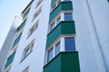 Facade of a new multi-storey building with white and green metal siding, many Windows Royalty Free Stock Photo