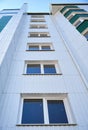 Facade of a new multi-storey building with white and green metal siding, many Windows Royalty Free Stock Photo