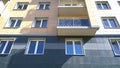 Facade of new multi-story residential building. Windows and balconies. Buying, selling, renting and insuring of economy class apar