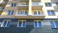 Facade of a new multi-story residential building. Windows and balconies pattern. Sale and rental of economy class apartments Royalty Free Stock Photo