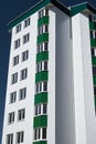 Facade of a new multistory building with white and green metal siding, many Windows Royalty Free Stock Photo