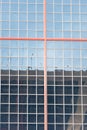 Facade of an office building with honeycomb windows and delimited in its center by a red steel cross Royalty Free Stock Photo