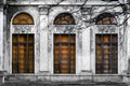 Facade of old abandoned building with three large arched windows of orange glass. Monochrome background Royalty Free Stock Photo