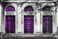 Facade of old abandoned building with three large arched windows of purple glass. Monochrome background Royalty Free Stock Photo