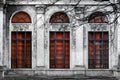 Facade of old abandoned building with three large arched windows of the red glass. Monochrome background Royalty Free Stock Photo
