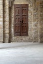 Facade of old abandoned stone bricks wall with grunge weathered wooden door Royalty Free Stock Photo