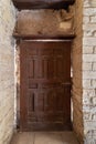 Facade of old abandoned stone bricks wall with grunge weathered wooden door Royalty Free Stock Photo