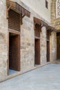 Facade of old abandoned stone bricks wall with three open weathered wooden doors Royalty Free Stock Photo