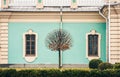 Facade of an old blue baroque building with lawn, decorative tree and boxwood bushes, Mariinsky Palace in Kiev, Ukraine