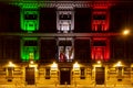 Facade of old brick building in Rome illuminated iby light in the colors of the italian Tricolore