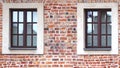 The facade of an old brick building with windows or cornices. Old brick walls