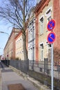 Facade of an old brick factory building with a window front in Augsburg / Germany, next to a footpath and no-stop signs and an